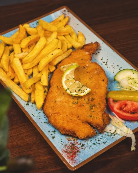 Paniertes Schnitzel mit Zitrone und Pommes bei Zaki’s